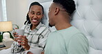 Couple, bed and talking with coffee at home for conversation, bonding and morning talk. Black man and woman together in morning with tea cup for discussion, healthy marriage and happiness in bedroom