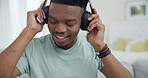 Black man, headphones and dancing to music, relax at home with audio streaming and stress relief. Listening to radio, technology and subscription, energy and entertainment, lounge on couch with app