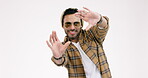 Hands, frame and a man photographer in studio on a white background to measure or size a picture. Portrait, creative and photography with a happy young hipster in preparation for a photoshoot