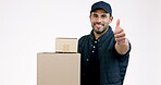 Happy man, box and thumbs up in delivery, thank you or approval success against a grey studio background. Portrait of male person or courier guy smile with like emoji, yes sign or OK for supply chain