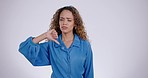 Thumbs down, face and hands of woman in studio for rejection of bad news, emoji sign and no feedback on white background. Portrait of sad model show negative review, wrong decision or fail of mistake