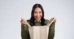 Wow, surprise and woman face with shopping bag in studio excited for sale, discount or gift on grey background. Present, portrait and happy female customer with store giveaway, deal or retail prize