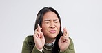 Luck, fingers crossed and Asian woman on a white background with hope, wish and excited in studio. Emoji, winner and portrait of isolated person with hand gesture for winning, competition or giveaway