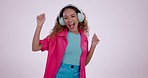 Happy woman, dancing and listening to music on headphones in celebration against a studio background. Fun energy and excited female person enjoying audio streaming, radio or sound track in happiness