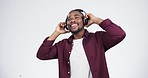 Music, headphones and black man dance in studio celebration with news, feedback or promo on white background. Freedom, happy and African model dancing to earphones radio, podcast or audio streaming