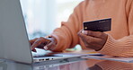 Woman, hands and laptop with credit card in online shopping, payment or banking at home. Closeup of female person typing on computer with debit in ecommerce, transaction or bank details on table