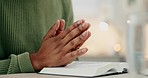 Praying, hands and woman with bible in her home for worship, hope or trust in Jesus Christ. God, pray and female with holy book for gospel, scripture and prayer for sorry, help or spiritual thank you