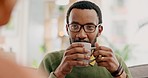 Home, talking and black man drinking coffee, happy and conversation with gossip, listening to a story or relax. African person, latte or guy on a couch, discussion or cappuccino on a break or bonding