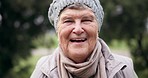 Senior person, smile and face in a park for a walk in retirement with wellness and gratitude. Nature, woods and elderly portrait with travel and winter vacation happy from garden and on holiday