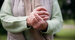 Hands, pain and a senior person with arthritis outdoor at a park in summer closeup during retirement. Anatomy, osteoporosis or joint massage with an elderly adult in a garden for a medical issue