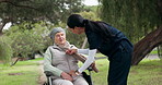 Nurse, elderly care and patient on wheelchair in nature, support or trust for assisted living at an outdoor park. Female caregiver helping senior person with a disability in healthcare or retirement