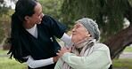 Nurse, park and a senior woman in a wheelchair at the park, talking together for communication or conversation. Healthcare, medical or retirement with a carer and patient walking outdoor in a garden