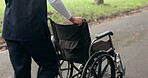 Walking, healthcare and a nurse with a wheelchair in the road for a patient or medical work. Morning, park and a doctor or caregiver with hospital gear in the street for nursing or rehabilitation