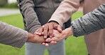 Elderly people, hands together and fitness in team motivation or support in outdoor unity at old age home. Closeup of senior group piling in teamwork goals, mission or exercise and workout in nature