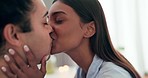 Love, kissing and young couple at their home relaxing, bonding and resting together on a weekend. Happy, smile and interracial man and woman with intimate romance, connection and trust in apartment.