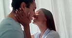 Couple, bedroom and kiss with love, morning sunshine and romance on holiday, care and happy in home. Young man, woman and smile with embrace, trust and lens flare in house, apartment or vacation