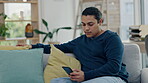 Man, relax on couch and smartphone, social media scroll and communication, tech and internet. Connectivity, using phone and mobile app, reading and search website in living room with texting at home