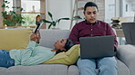 Technology, relax and website with a couple on a sofa in the living room of their home together for social media browsing. Laptop, tablet or internet with a young man and woman in their apartment