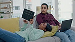 Technology, relax and internet with a couple on a sofa in the living room of their home together for social media browsing. Laptop, tablet or website with a young man and woman in their apartment