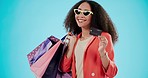 Portrait, woman with credit card and shopping bag for fashion isolated on a blue background mockup space in studio. Happy, gift and African customer with plastic money in sunglasses for retail sales