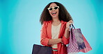 Fashion, shopping bag and happy with woman in studio for designer boutique, retail and wardrobe. Product, choice and luxury brands with customer on blue background for promotion, gift and sales