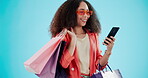 Smile, woman with shopping bag and phone for fashion isolated on blue background mockup space in studio. Happy, gift and African customer with mobile in sunglasses for ecommerce sales on social media