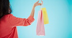 Luxury, shopping bag and hands of woman in studio for designer boutique, retail and wardrobe. Product, choice and fashion with closeup of customer on blue background for promotion, gift and sales