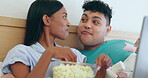 Movie snack, bed and couple popcorn with laptop series and streaming with eating and bonding. Food, online and hungry people in a bedroom with computer and film subscription together with dessert