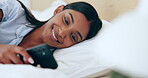 Happy, relax and a woman with a phone in bed for social media, online chat or notification. Smile, morning and a young Indian girl with a mobile for an app, reading communication or typing in a house