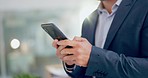 Business man, hands and phone networking in a office with text and online job search. Company, professional and mobile contact with social media scroll and message on a website and app at workplace