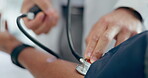 Doctor, patient and stethoscope on arm for blood pressure, healthcare consultation and test in clinic. Closeup, hands and medical expert check pulse, hypertension and wellness analysis in hospital 