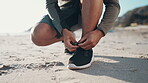 Feet, runner and tie shoes at beach for running, workout and fitness performance. Closeup, hands and athlete lace sneakers, footwear and prepare on sand at sea for exercise, sports or summer training