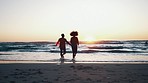 Sunset, running and couple in the ocean at the beach on vacation, adventure or holiday together. Love, happy and back of man and woman holding hands, bonding and having fun by the sea on weekend trip