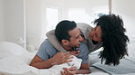 Talking, hug and couple in bed, funny and bonding together in home to laugh. Embrace, interracial love and man and woman smile in bedroom in conversation, healthy connection and relax in the morning