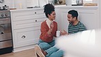 Coffee, laughing and a couple on the kitchen floor in their home together for funny humor or joking. Love, smile or happy with a playful man and woman talking in a house to relax while drinking tea