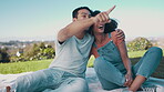 Love, picnic and pointing with couple in nature for summer vacation, relax and happiness. Bonding, hug and commitment with man and woman on date in park for wellness, romance and anniversary together