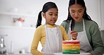 Cake, candles and baking with child and mom together with helping in a kitchen. Happy, parent support and birthday food for rainbow dessert in a family home with learning and cooking with mother