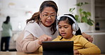 Tablet, education and a girl learning with her grandma in the home living room during a family visit. Technology, study or homework with a senior woman teaching her granddaughter in a house together