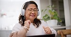 Dance, headphones and mature woman singing in the living room for relaxing or scroll on laptop. Technology, online and Asian female person moving and listening to music, playlist or radio at her home