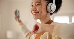 Young woman, headphones and dancing in living room, home or happy for music, sound tech or listening. Dancer girl, smile and thinking for audio streaming subscription, smartphone or excited in lounge