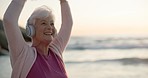 Dancing, headphones and senior woman at the beach for outdoor cardio workout or training. Happy, energy and elderly female person moving and listening to music, playlist or radio by ocean at sunset.