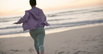 Back, freedom and energy with a woman at the beach for running, fitness or training in nature. Summer, sunset and excitement with a female tourist by the ocean for travel, vacation or holiday