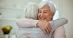 Hug, love and senior woman friends in the living room of their home during a visit in retirement. Smile, welcome and a happy elderly person embracing her sister while feeling excited together