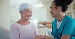 Support, conversation and senior happy woman with nurse for healthcare, elderly care or patient consultation. Holding hands, retirement home and mature person discussion with caregiver on lounge sofa