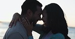 Love, sunset and kiss with couple at beach for relax, summer vacation and travel. Happy, adventure and wellness with man and woman hugging on seaside date for holiday, marriage and peace together