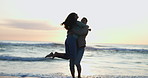 Happy, sunset and a couple with a hug at the beach for love, a date or romance together on holiday. Excited, summer and a man and woman with care at the ocean in the evening during a honeymoon