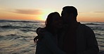 Beach sunset, kiss and relax couple silhouette, hug and bond on romantic date, holiday freedom or nature break. Sea waves, care and relationship people hugging with trust, marriage affection or love