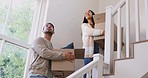 Cardboard, boxes and couple moving or walking in new house and happy with investment in real estate, property or mortgage. Dream, home and people smile and move together on stairs in living room