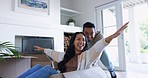 Couple, moving and fun at home with cardboard box race and freedom at new property. Happy, smile and woman and man together playing in house with celebration and dream household with games on floor