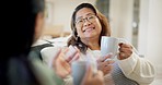 Home, mother and daughter with coffee, conversation and family on a couch, relax and funny in a lounge. Women, mama or girl on a sofa, tea or cappuccino with discussion, latte or laugh in living room